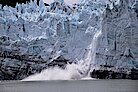 Eis bricht von einem Gletscher ab und fällt ins Wasser