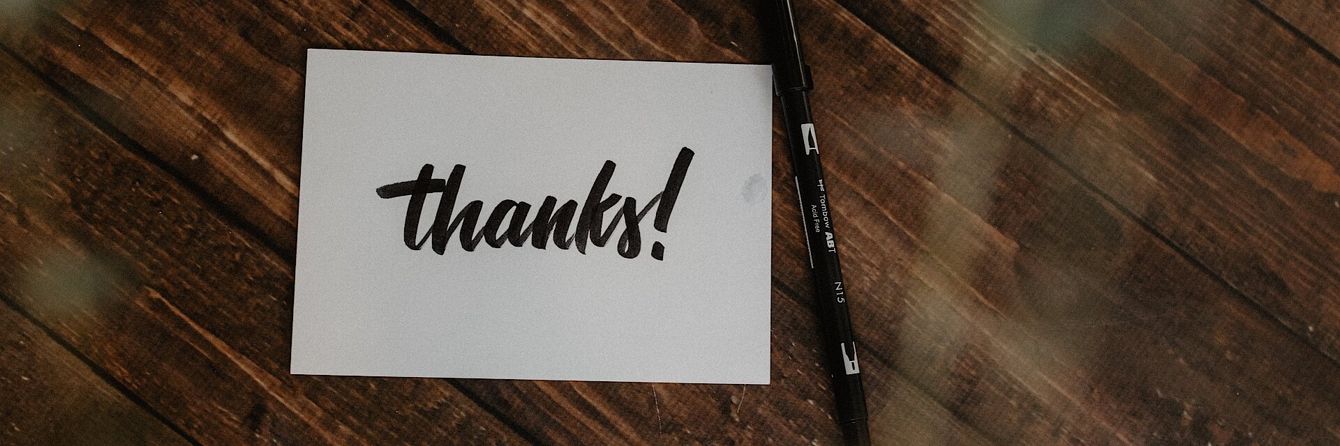 Blatt auf dem "thanks" steht, liegt auf einem Tisch Blatt auf dem "thanks" steht, liegt auf einem Tisch